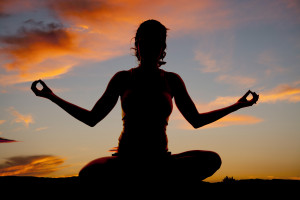 donna fa yoga al tramonto